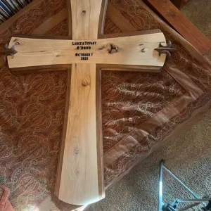 large 2 toned wooden cross with couple's names and wedding date carved into it